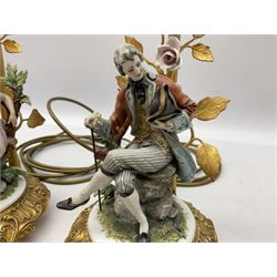 Pair of Capodimonte figural lamp bases, depicting a male and female upon a tree, both on a metal gilt stand with floral detail, H32.5cm