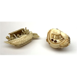 A Japanese carved ivory Netsuke, modelled as a seated figure with monkey companion, signed beneath, H3.5cm, together with a carved ivory model of a traditional boat surmounted by four figures, L6.5cm.
