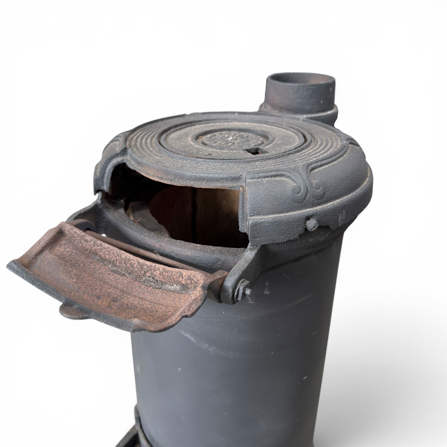 Late Victorian cast iron stove of small proportions, decorated with scrolls and central rosette to the top