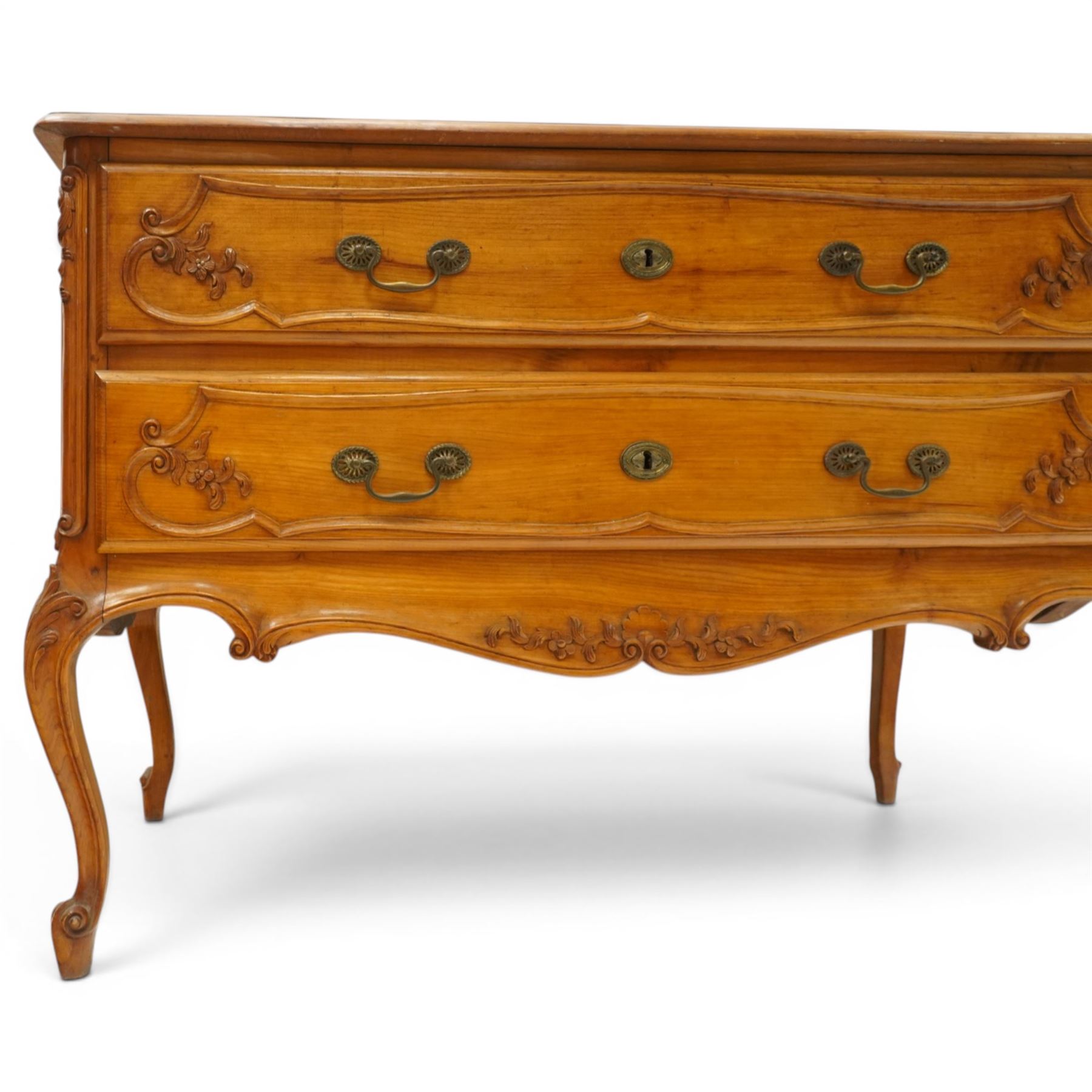 Early 20th century French fruitwood commode chest, rectangular top with moulded edge, fitted with two long drawers with moulded scroll and floral decoration, shaped apron with moulded scallop motif and trailing foliate, raised on cabriole legs with acanthus carved knees and scroll feet