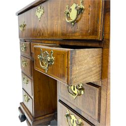 Early 18th century Queen Anne figured walnut kneehole desk with secretaire drawer, moulded and book matched top with walnut band, the top drawer with fall front enclosing small drawers and pigeon holes, fitted with nine drawers and central recessed cupboard, on ogee bracket feet