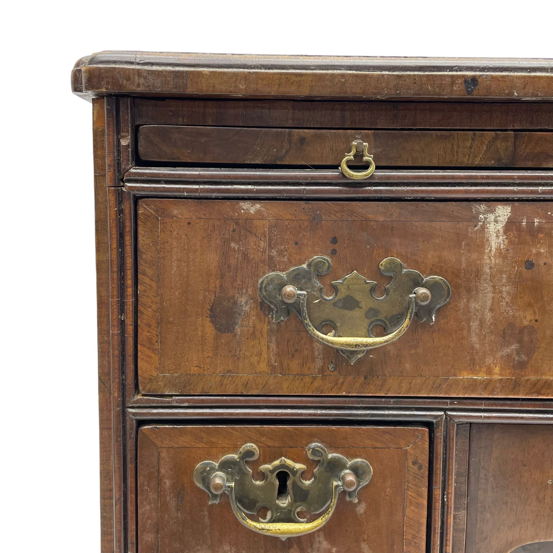 Georgian walnut kneehole desk, moulded rectangular top with book-matched veneers within crossbanding, fitted with slide over one long drawer, frieze drawer, six small drawers and recessed cupboard, raised on bracket feet