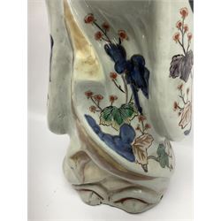 Large Japanese Imari porcelain figure, modelled as a Bijin, wearing a long kimono decorated with apple blossom and leafy branches on a white ground, with gilt detailing, possibly Edo period, H63cm