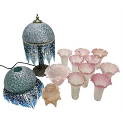 Tiffany Style table lamp with a mottled glass shade with a beaded fringe, together with a matching shade and a set of nine tiffany style lampshades with mottled decoration and fluted rim and two others 