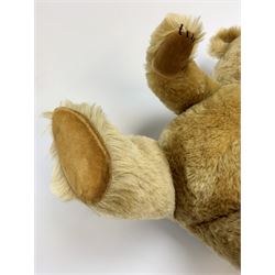Chiltern Hugmee large teddy bear c1950s with kapok filled long-plush body, jointed swivel head with original orange and black glass eyes and vertically stitched nose and mouth, jointed limbs with card lined feet and velvet covered pads and inoperative squeaker H22