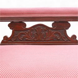 Late Victorian mahogany chaise longue, of scroll-ended form, upholstered in red diamond-patterned fabric with padded back and scroll-carved support, open arm with carved foliate and turned upright, raised on turned tapering legs 