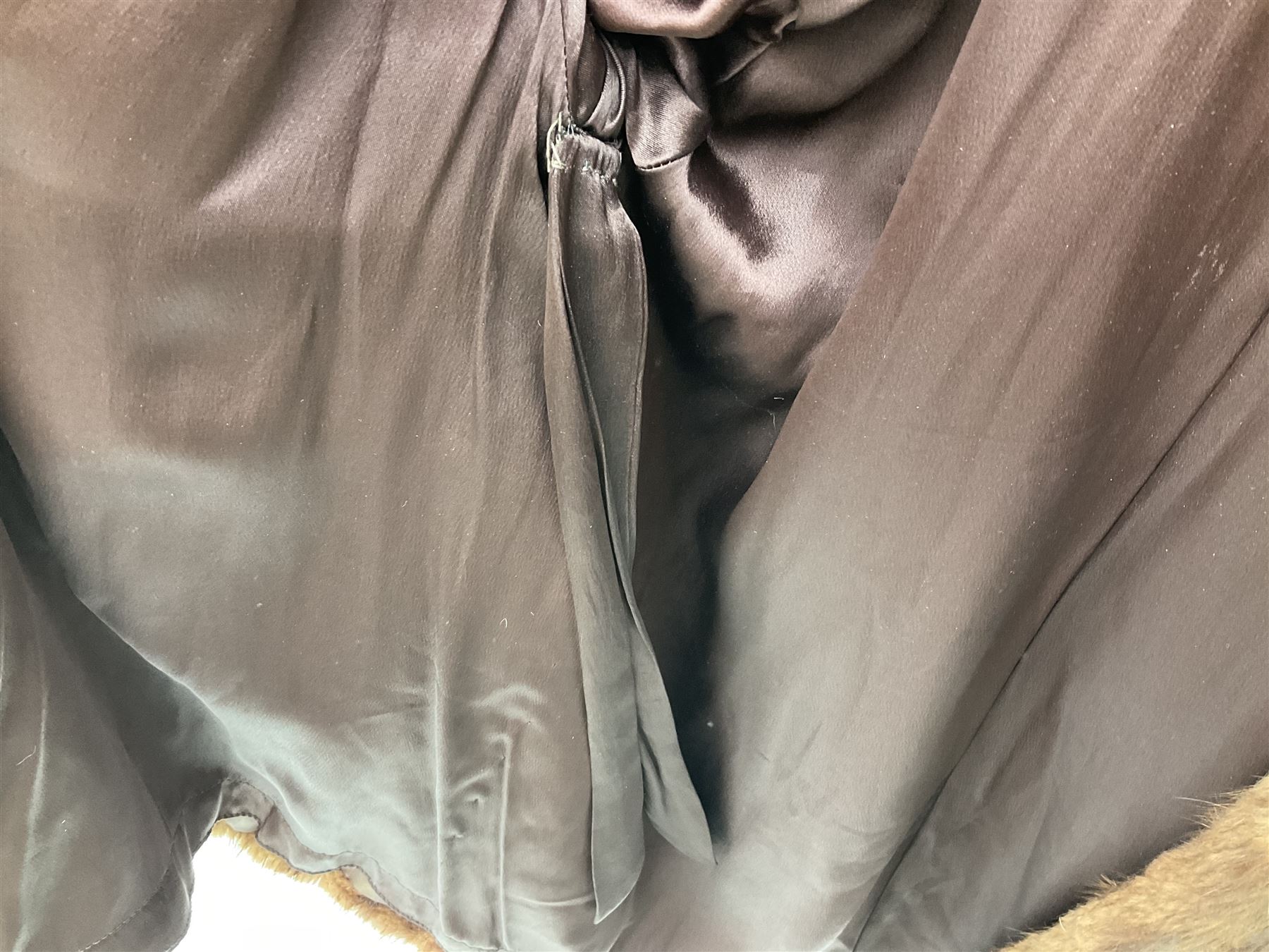 Brown mid length musquash fur coat by National Fur Company together with white rabbit cape