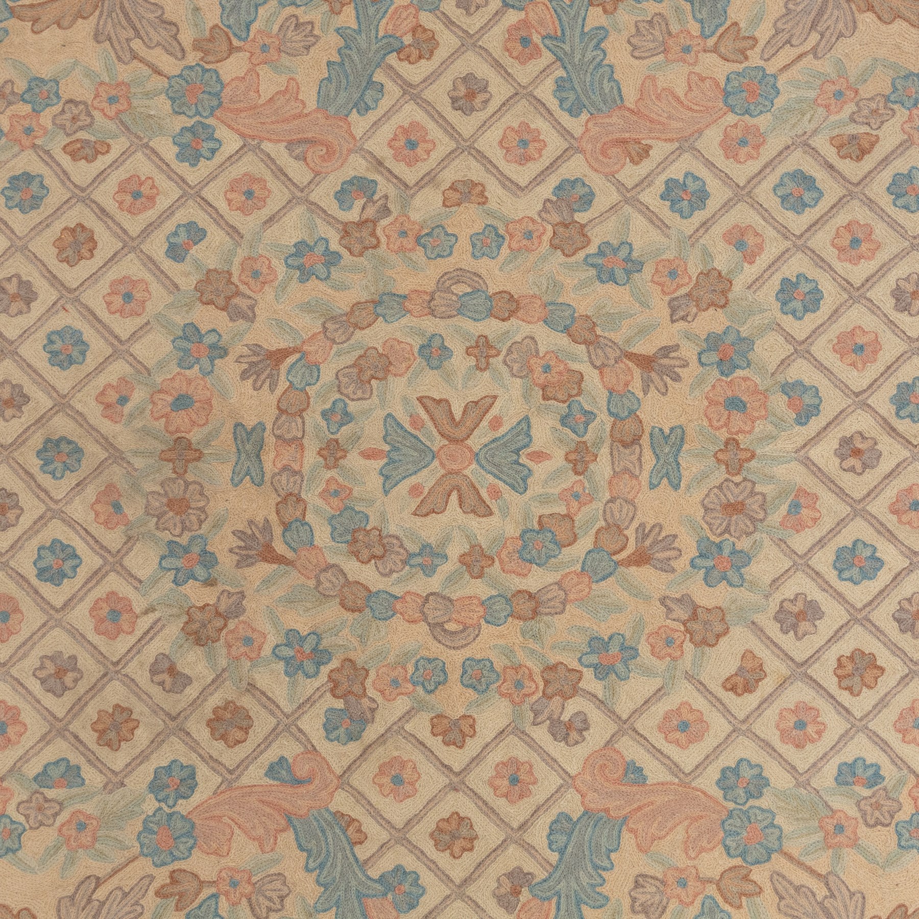 Aubusson design pale peach ground rug, woven with an all-over lattice design in rose and cyan with central floral bouquet medallion, the scrolling acanthi and flowerhead spandrels contained within a lattice guard band