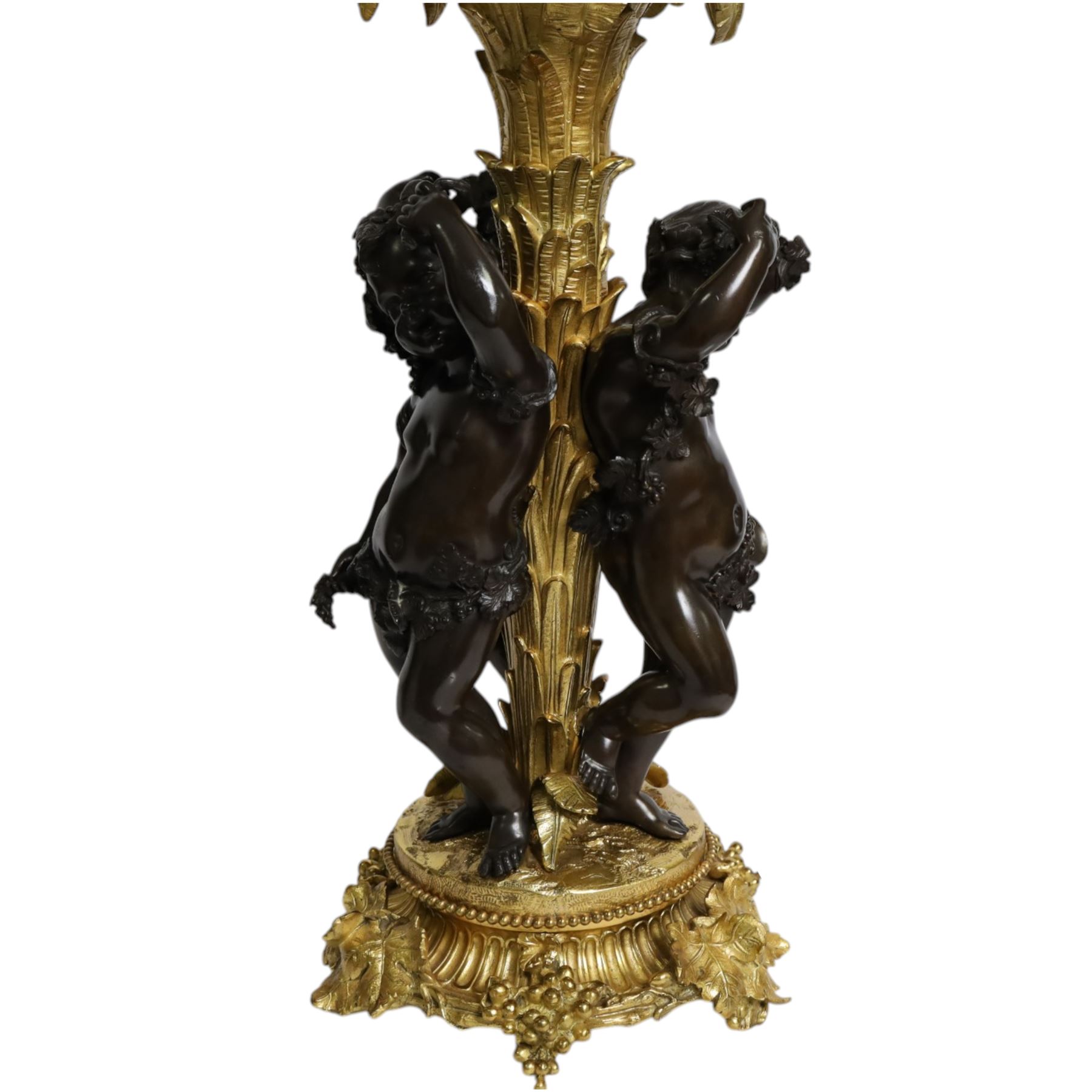 Louis XVI style gilt table lamp, the central column decorated with acanthus leaves, surrounded with three putti with vine leaf crowns, upon a circular base adorned with grape and vines, with shade, H64cm