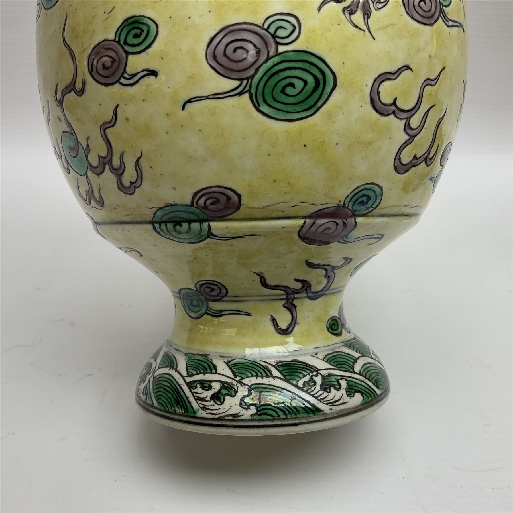 20th century Chinese Famille Verte vase, of slender ovoid form with tapering neck and flared rim, decorated with green and grey enamel with dragons chasing flaming pearls amongst auspicious clouds upon a yellow ground, H30cm