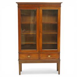 19th century mahogany enclosed bookcase on stand, projecting cornice and banded frieze over two glazed doors enclosing four adjustable shelves, fitted with two drawers to base, on square tapering supports