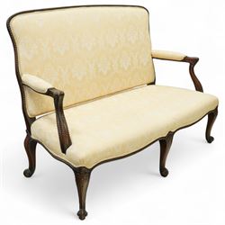 Early 20th century mahogany settee in the George III style, upholstered in pale yellow damask fabric, moulded serpentine seat rail with carved foliate detail, on cabriole supports with acanthus carved knees and scroll feet