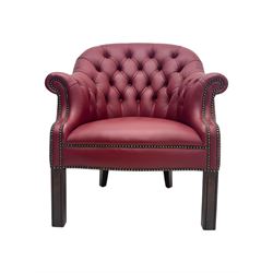 Kingsgate - contemporary 'Devon' bucket armchair, upholstered in red leather with buttoned backrest, rolled arms and brass stud detailing, raised on four dark wood supports with vertical carving