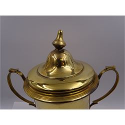 Edwardian silver-gilt twin handled trophy cup and cover, with two curved handles, the domed cover with urn finial, upon domed stepped foot and cylindrical mahogany base with applied plaque, hallmarked Skinner & Co, London 1908, total H29.7cm