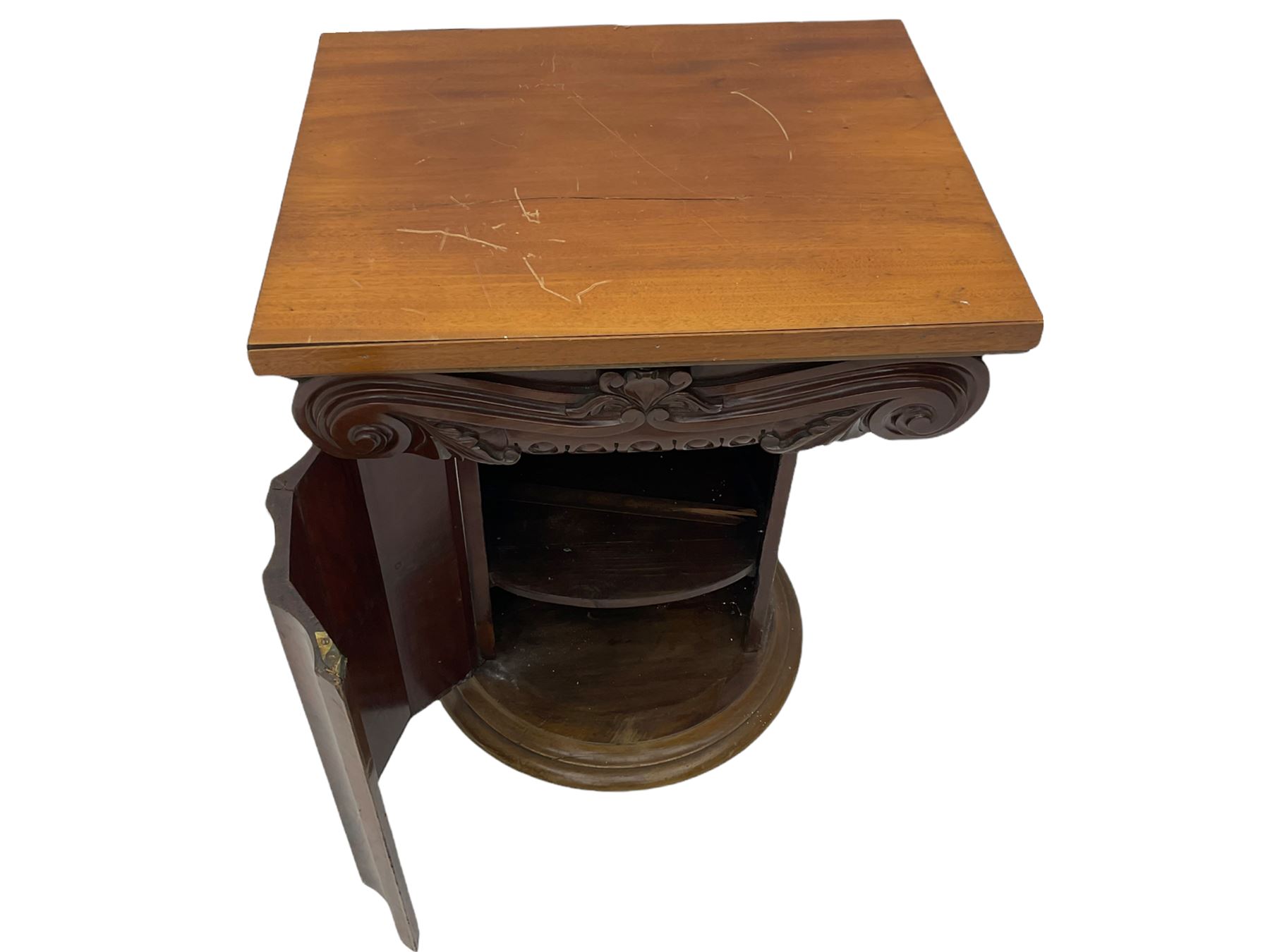Victorian mahogany vanity unit in the form of a column, the scrolled top with hinged lid revealing mirror, wash bowl and toiletry dishes, on scalloped cylinder pedestal with single door, the interior fitted with shelf