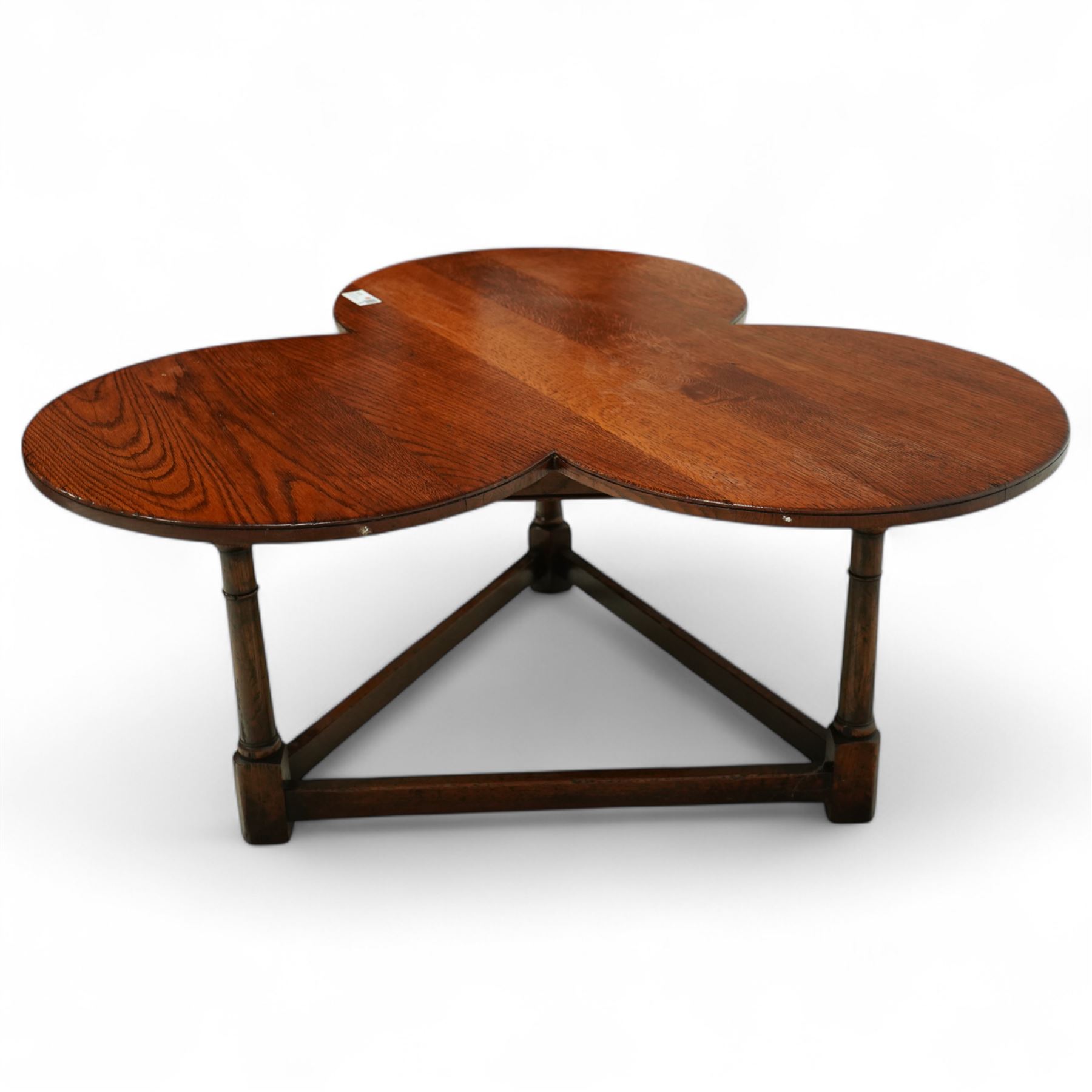 Mid 20th century oak trefoil shaped coffee table on ring turned supports joined by stretchers terminating in square feet 