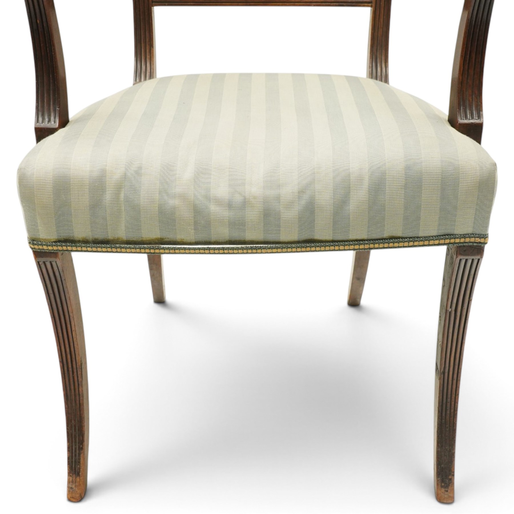 Georgian mahogany reeded carver armchair or elbow chair, bar back and scrolled arm terminals above over-stuffed seat, raised on sabre supports