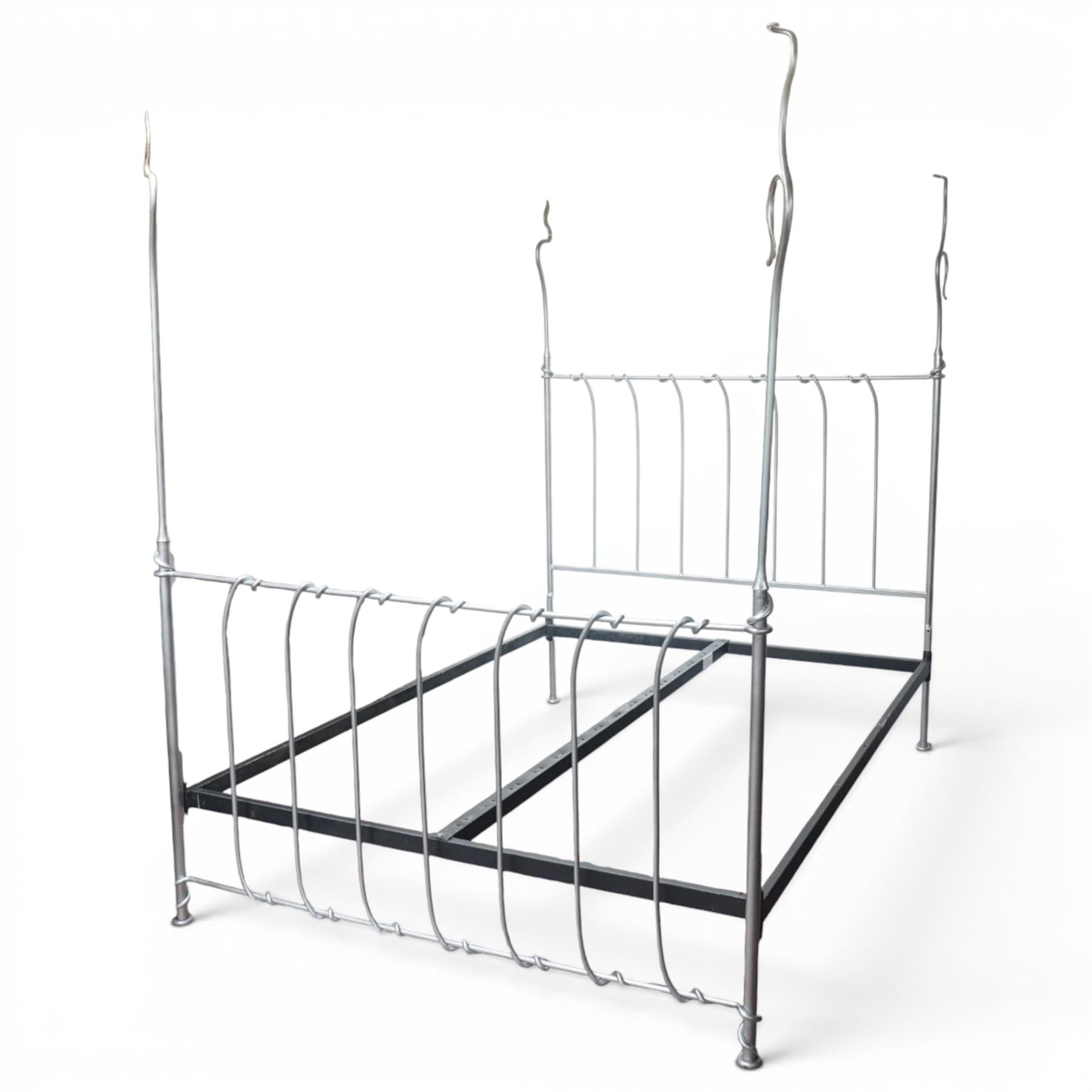 And So To Bed - 'Squigalina' silvered metal framed 5ft king size four poster bed, the tubular chrome posters in scrolling foliate form, over a shaped and scroll-topped metal spindle headboard and footboard