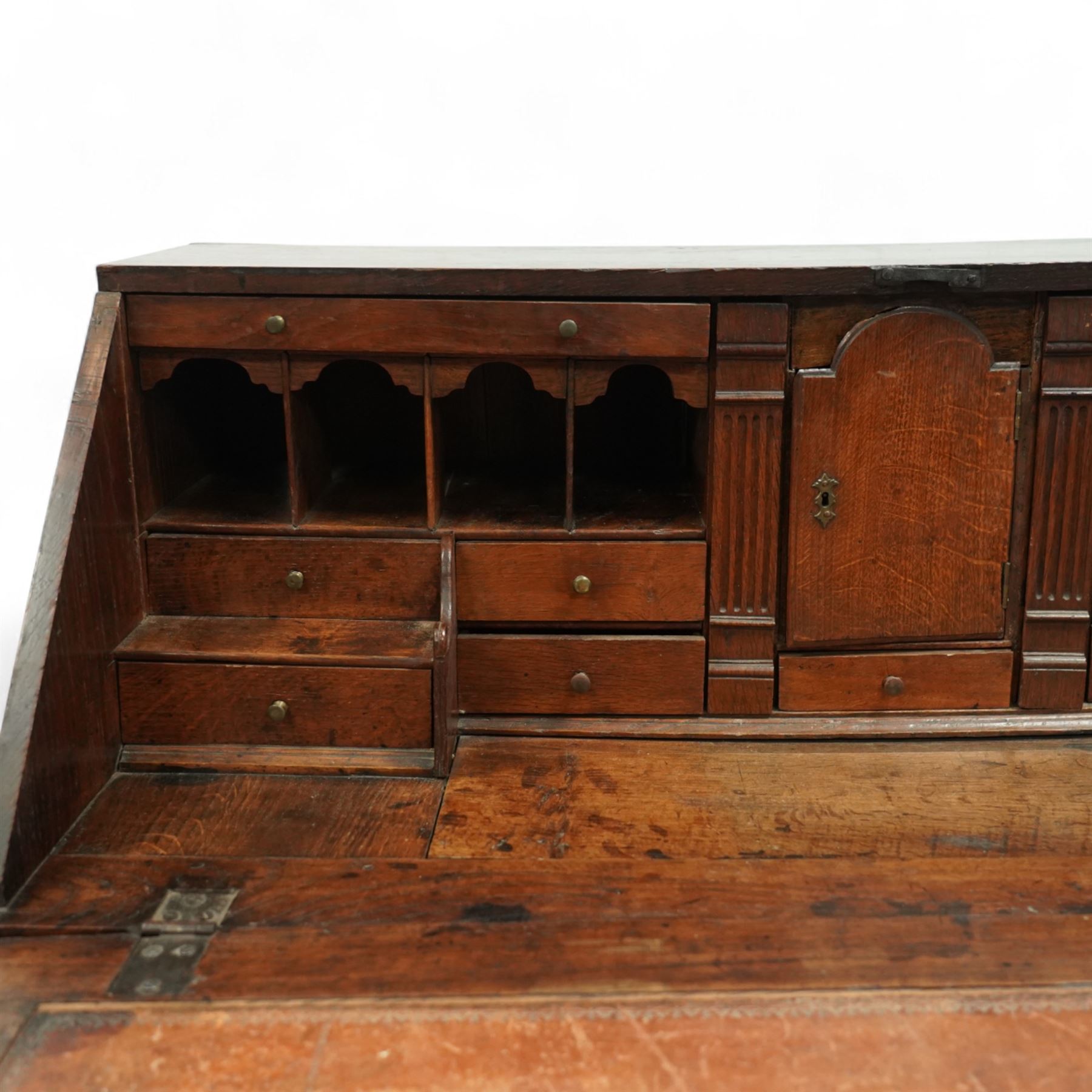 George III oak bureau, the fall front enclosing a fitted interior of small drawers and pigeonholes, above seven graduated drawers with brass plate handles and bone escutcheons, raised on bracket feet