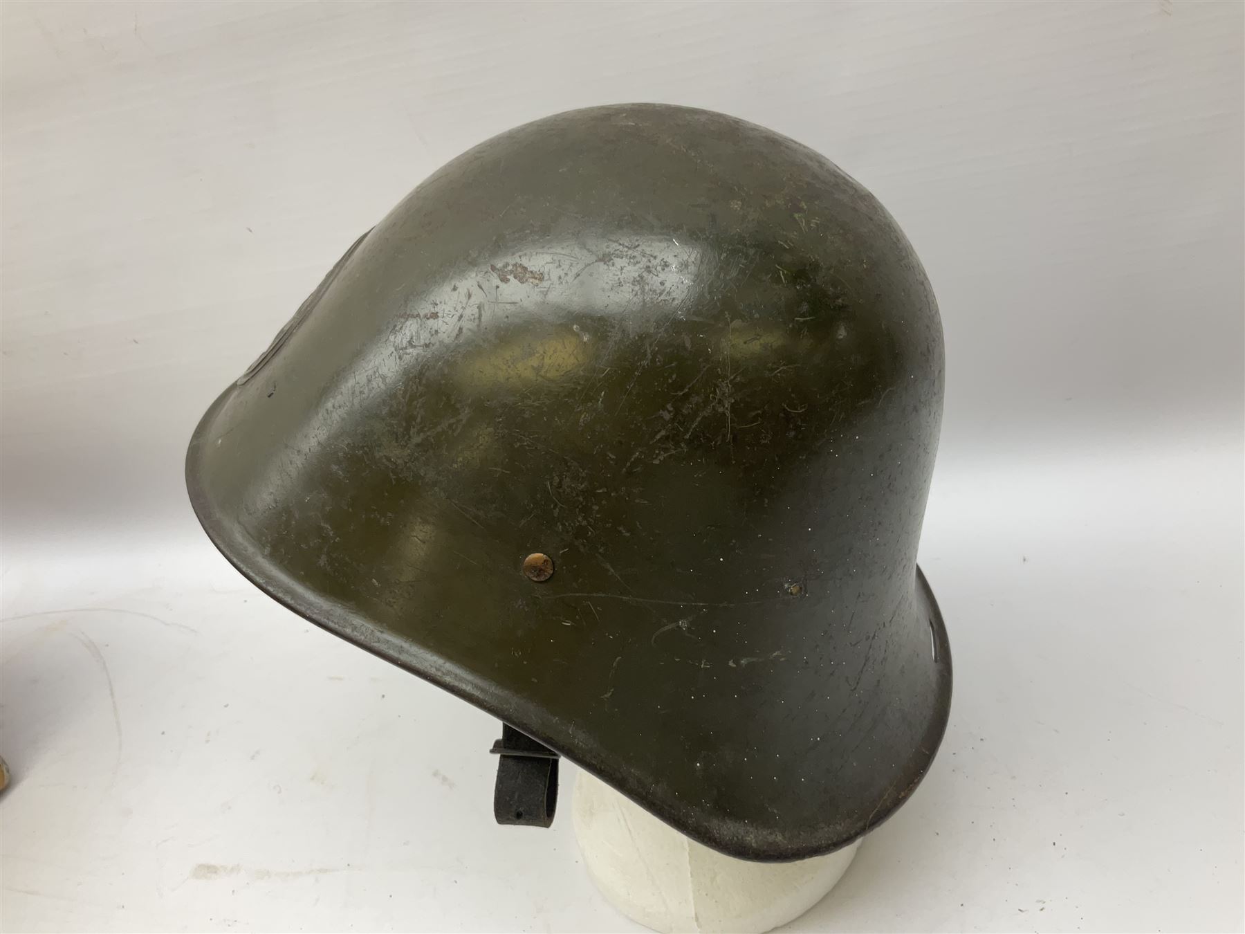 WW2 French M-26 Adrian Pattern Steel Helmet, original olive drab paint finish; flaming grenade badge to the front signifying issue to an Infantry regiment; original leather liner and leather chinstrap; and WW2 Dutch steel helmet with liner and chin strap (2)