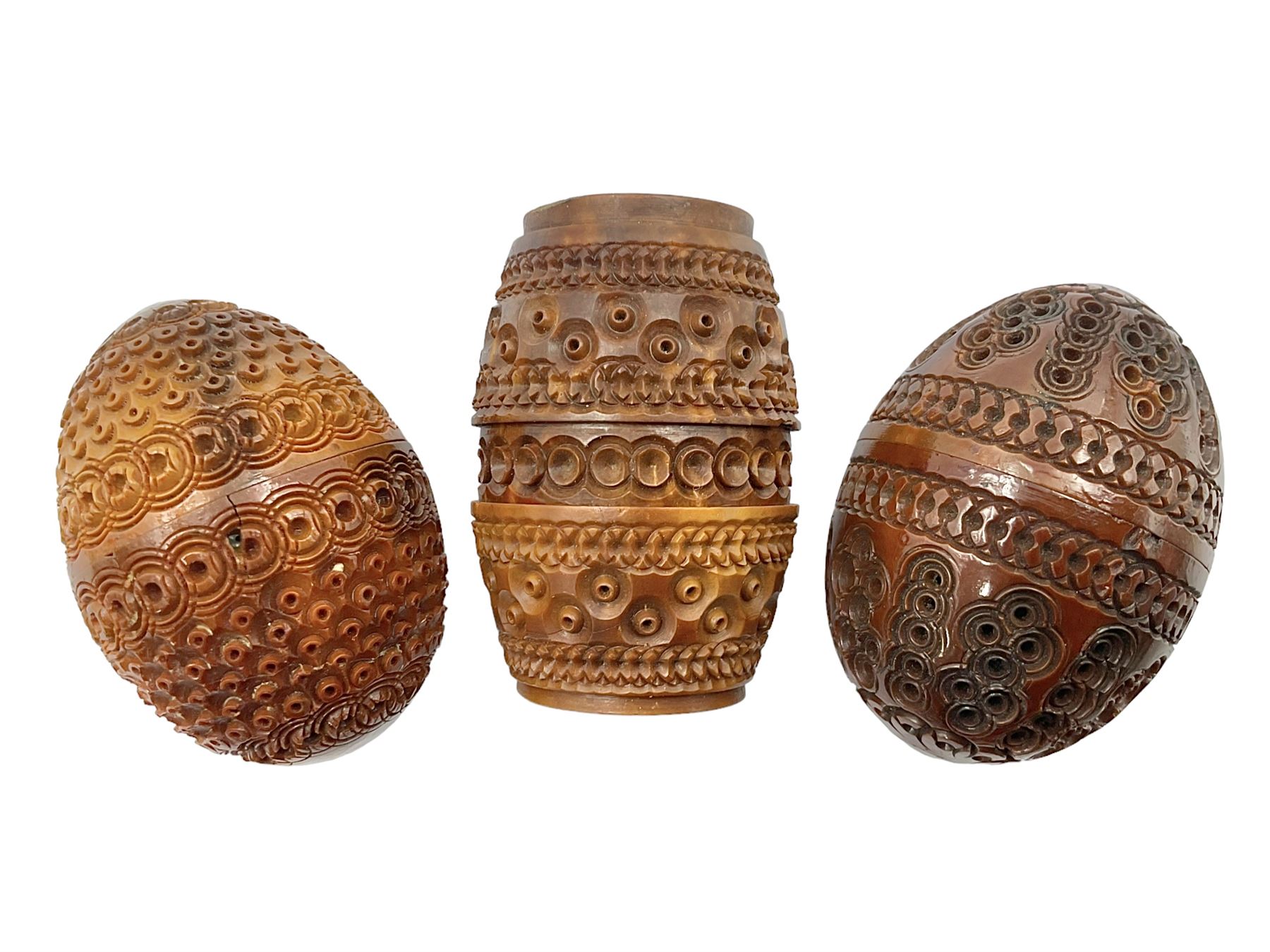Three 19th century coquilla nut pomanders or flea catchers, two of egg shaped form and the third of barrel from with carved and pierced decoration and screw threaded join, largest H8cm