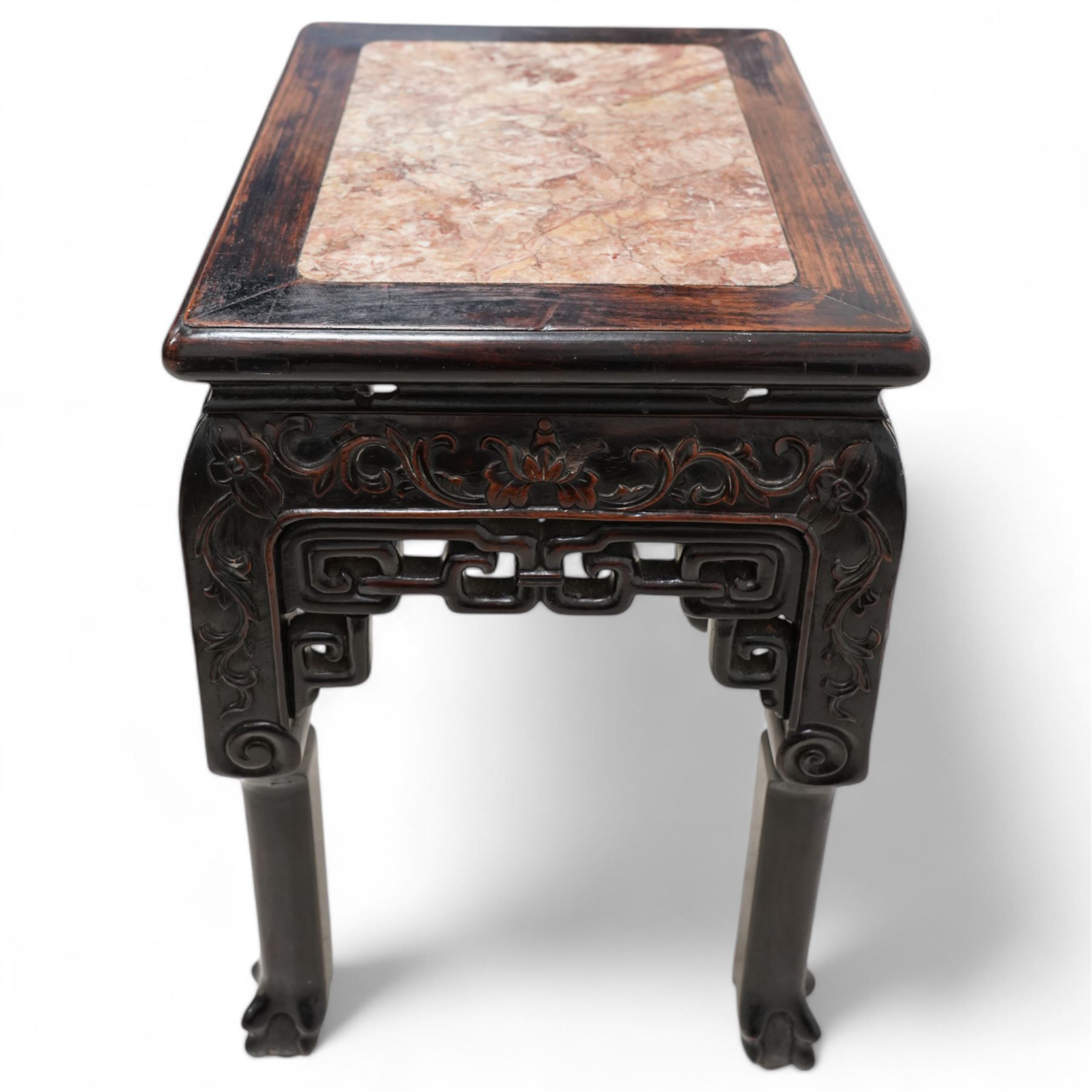 Early 20th century Chinese carved hardwood and marble urn stand, rectangular moulded top with inset variegated rouge marble, carved with curling leafy branches and scrolls, shaped and pierced brackets, on ball and claw carved supports 