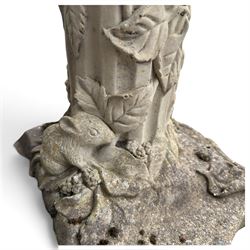 Weathered cast stone birdbath, the kylix shaped bowl with fluted body, raised on a fruiting foliate vine decorated fluted pedestal with upper knop and bird and fieldmouse motifs, shaped square base with scroll feet