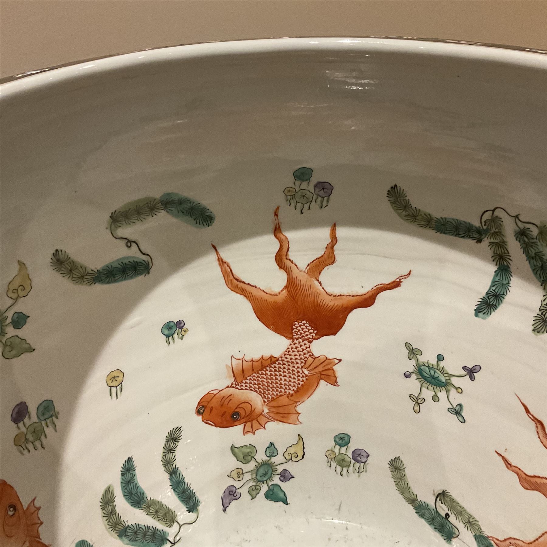 Large 20th century Chinese famille noir glazed porcelain jardinière, of ovoid form, the exterior enamelled with butterflies and white cranes amidst blossoming water lilies and pads against a black ground, between two stylised polychrome borders and beneath a key border to rim, the interior enamelled with red koi fish swimming amongst water fronds and weeds, with printed red character mark beneath, the whole upon an ebonised hardwood stand with three cabriole legs, jardinière H42cm D47cm, including stand overall H69.5cm
