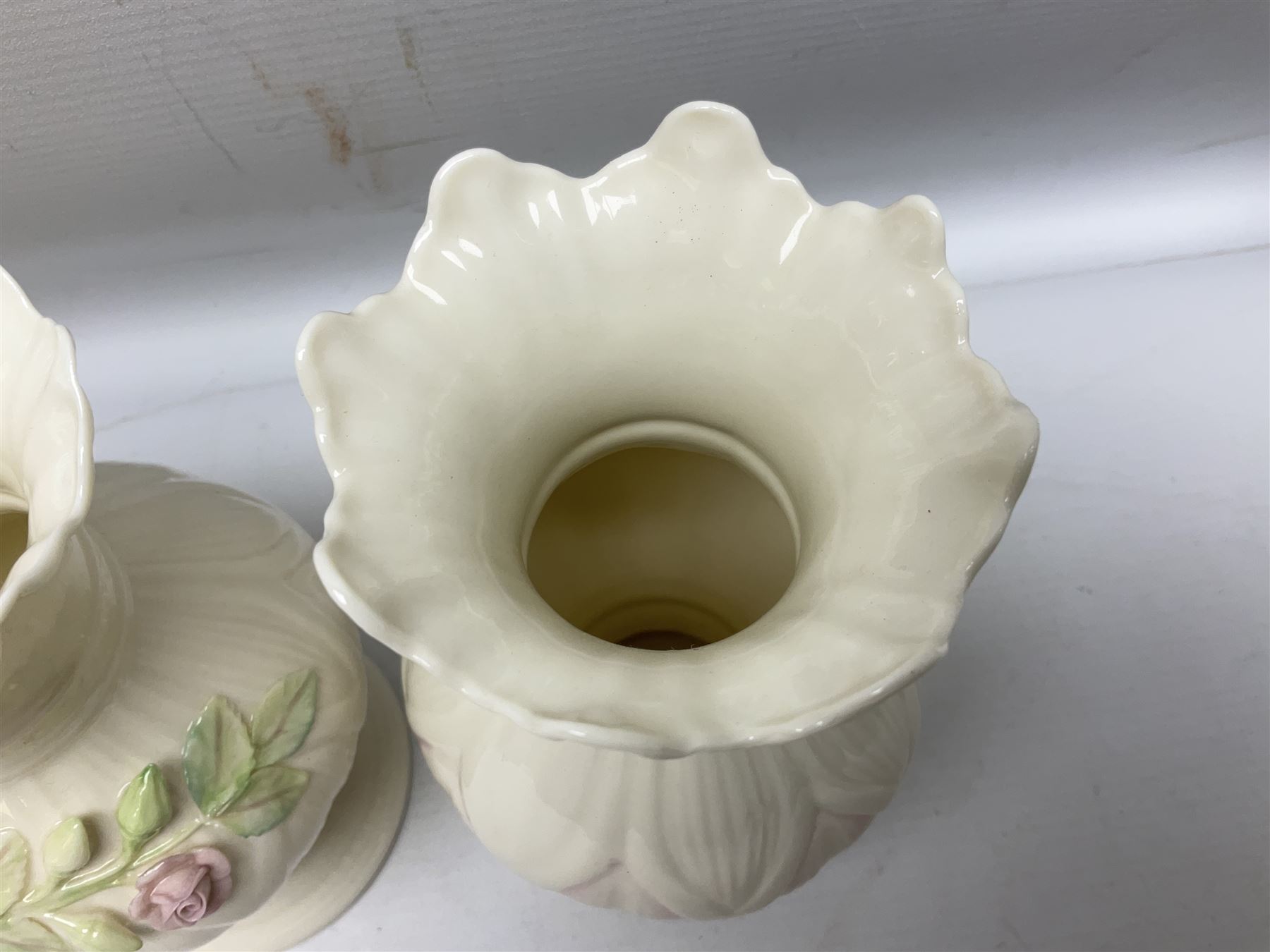 Five late 19th/early 20th century and later Belleek vases, comprising pair of Lotus Blossom examples, shamrock tree trunk vase, twin handled shamrock vase and a baluster form vase decorated with applied roses, all with printed marks beneath, tallest H16cm