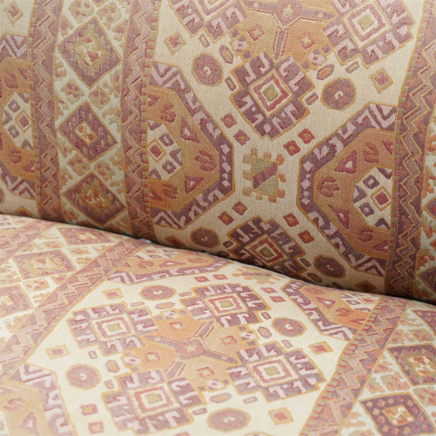 Late Victorian walnut chaise longue, upholstered in geometric patterned fabric, the scroll end and padded back above carved side panel with foliate and roundel motifs, shaped seat rail on turned front supports with ceramic castors