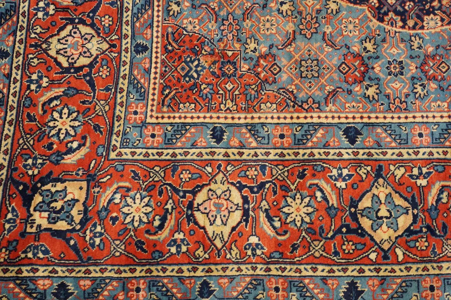 Persian indigo ground Herati rug, the busy field with a central lozenge pole medallion surrounded by repeating Herati motifs, within a shaped spandrel border the crimson guard band decorated with repeating palmette motifs