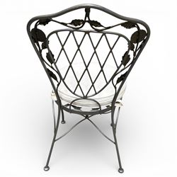 Wrought iron garden dining table with leaf decoration, and set of four matching chairs