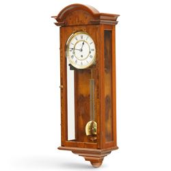 Comitti of London - burr walnut three-train wall clock, the circular dial with Roman numerals, glazed case revealing the movement and brass pendulum