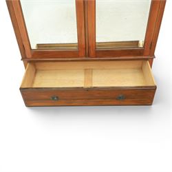 Edwardian walnut double wardrobe, featuring two mirrored doors with bevelled plates, carved frieze with fluted pilasters, above single base drawer