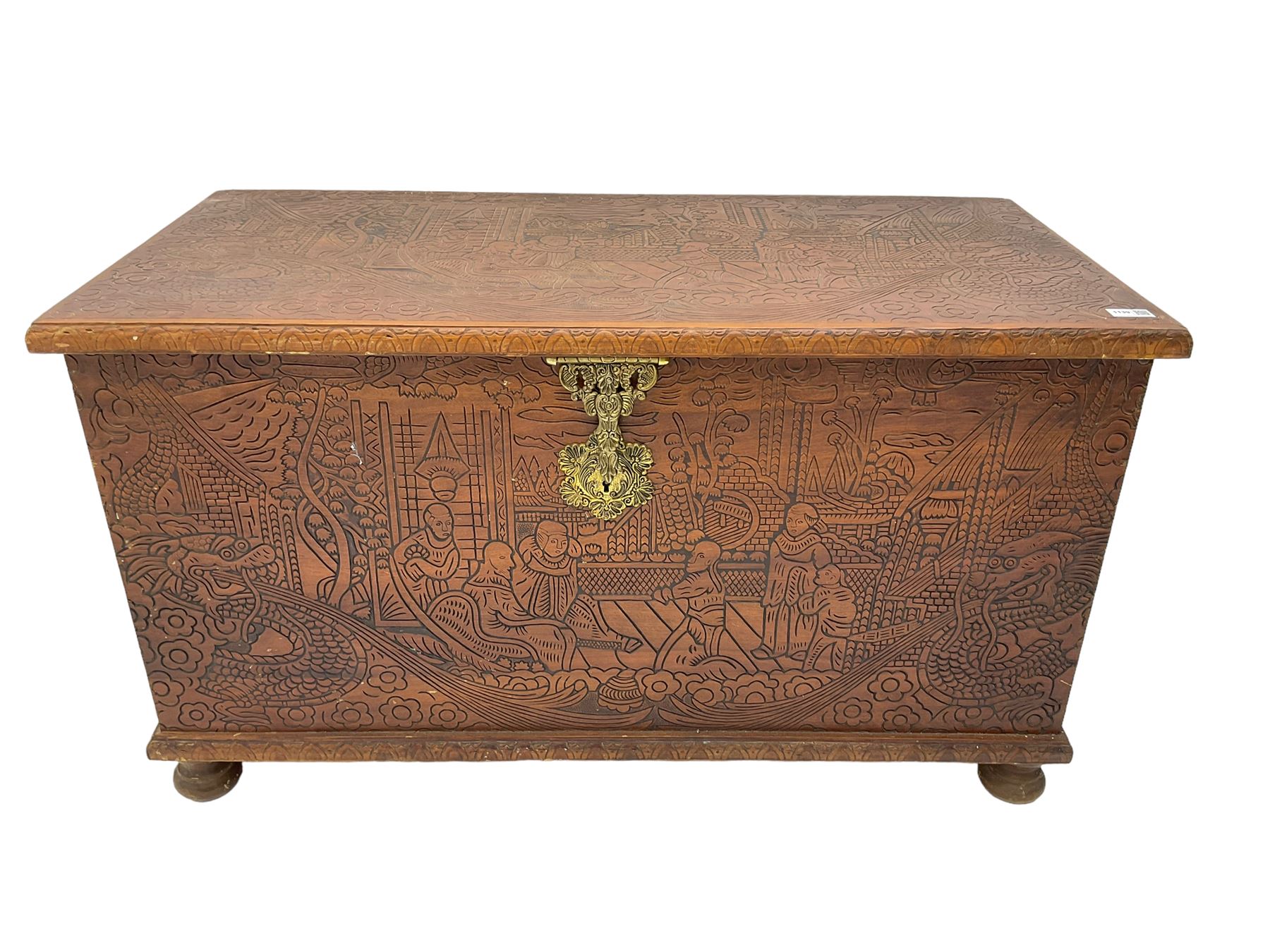 Hong Kong camphor wood chest, rectangular hinged top, carved all over with traditional scenes and dragon boats, on bun feet