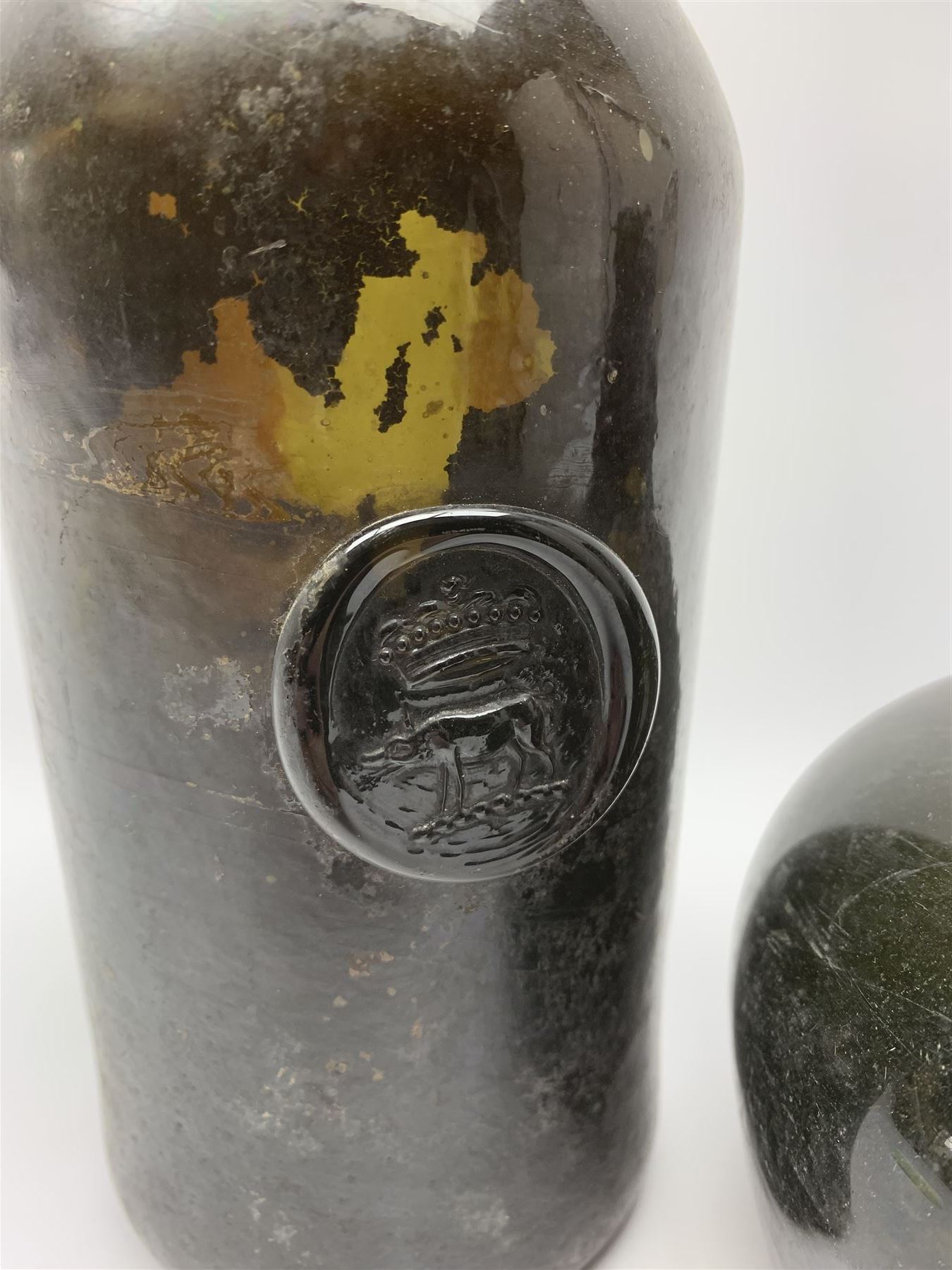 18th century green glass bottle, of onion form, H15cm, together with an 18th century green glass wine bottle, with seal depicting a boar beneath a crown, probably the Edgcumbe Crest, H27cm