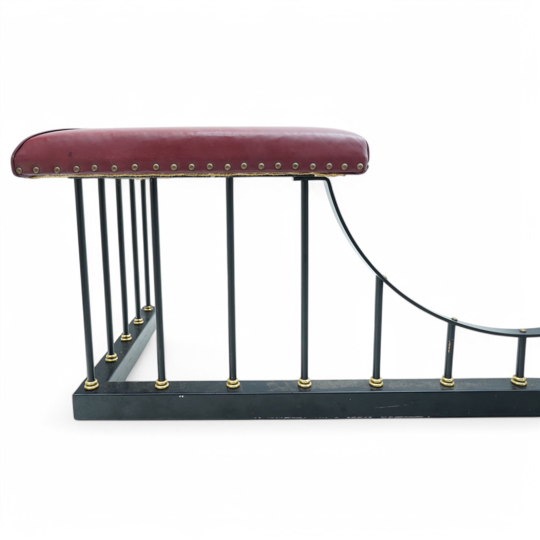 Wrought metal and brass fire fender, L-shaped corner seats upholstered in burgundy fabric with stud bands, dished centre on balustrade and plain curb  