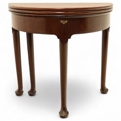 20th-century Georgian Revival style double fold-over card table, the first hinged circular top with polished mahogany surface above a second hinged circular top revealing a green baize playing surface with four counter-wells, underneath with a recessed compartment with and  chip and dice wells, the apron with fitted lock and key, raised on slender straight legs with pad feet 
