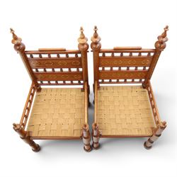 Pair of Anglo-Indian brass inlaid hardwood low chairs, the backs with turned spindle rails and rectangular panels inlaid with scrolling foliate decoration, woven rush seats within moulded frames, raised on turned supports with ring turned feet