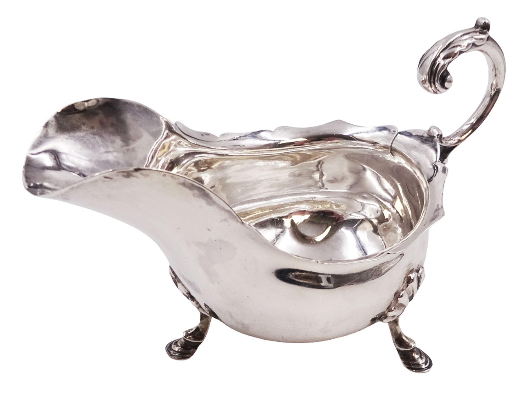 Victorian silver sauce boat, of typical plain form, with shaped rim and acanthus capped flying scroll handle, upon three hoof feet, hallmarked Walker and Hall, Sheffield 1899, including handle H12cm