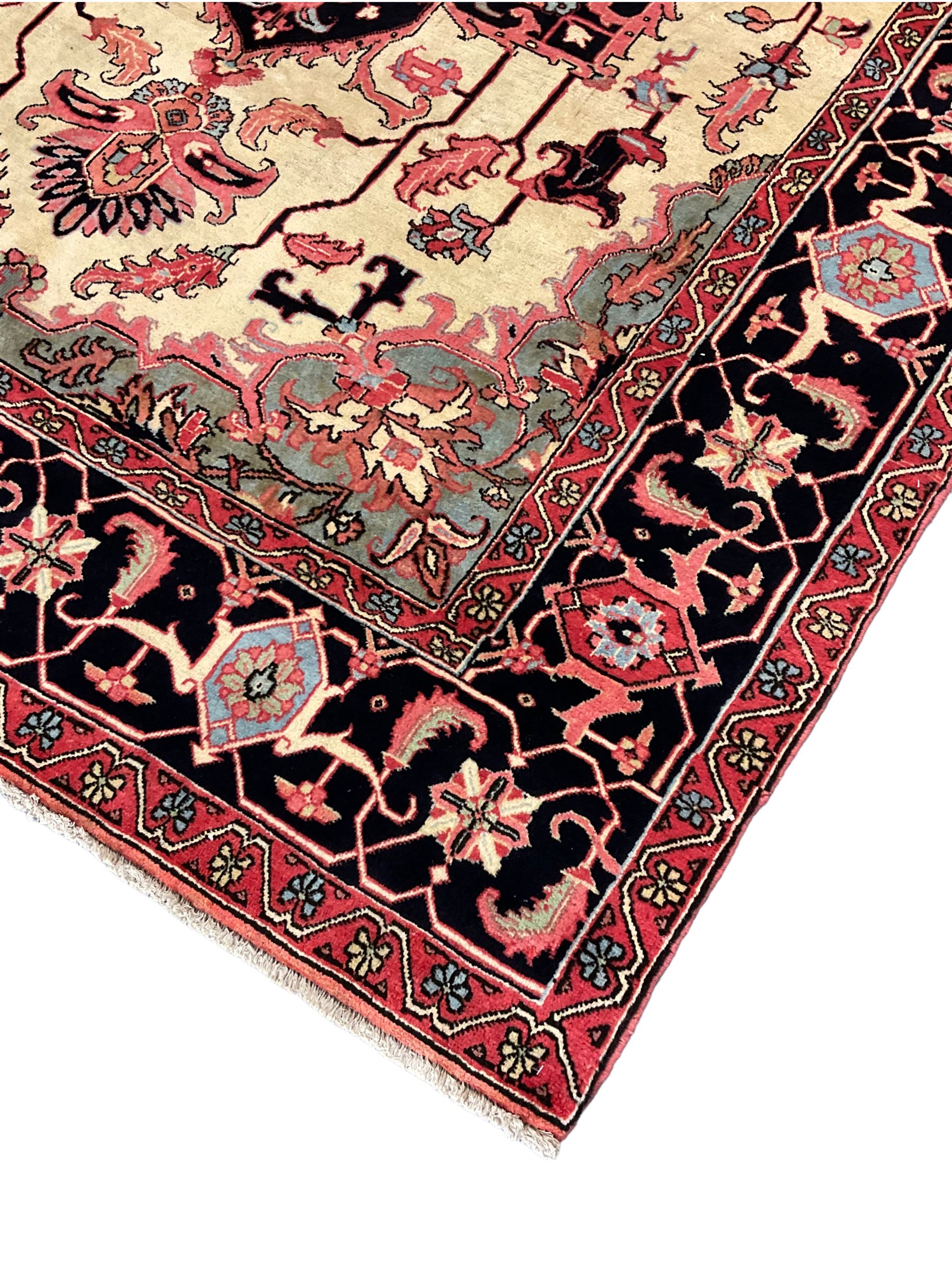 North West Persian Heriz carpet, ivory ground with large central medallion and floral spandrels, triple band border with scrolling design decorated with flower head and plant motifs 