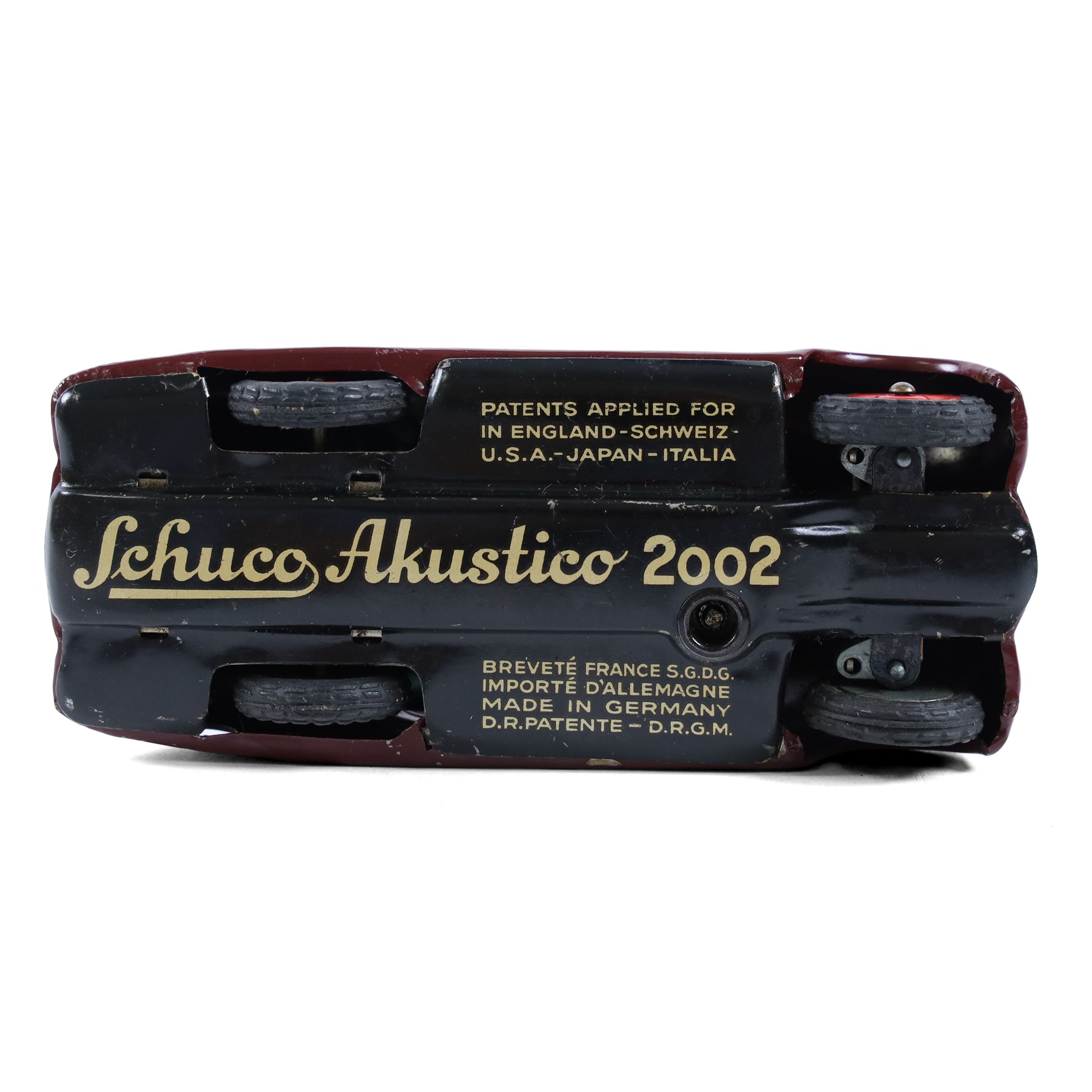 Schuco Akustico 2002 tinplate clockwork car, in burgundy with green metallic interior, with key