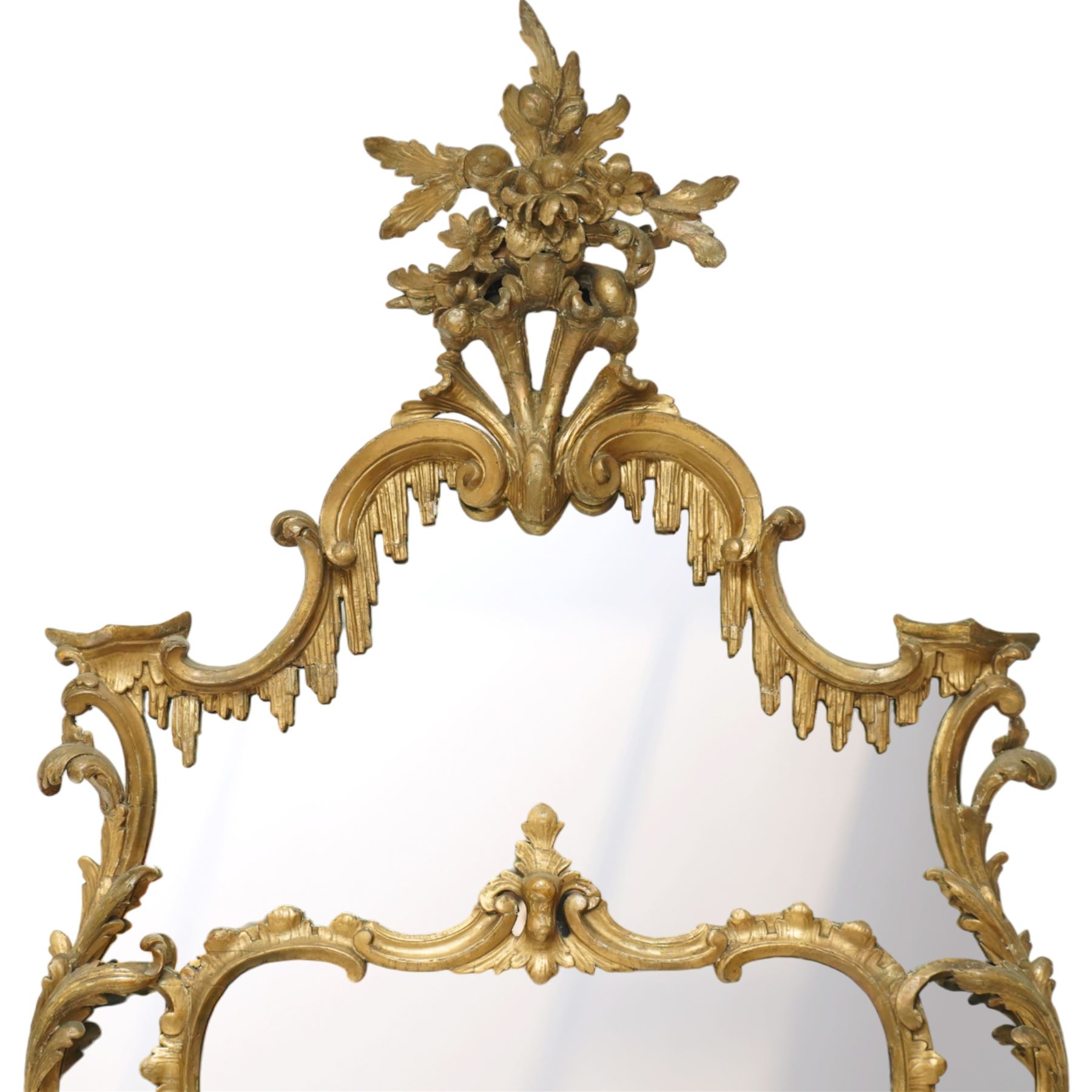George III Chippendale design carved giltwood and gesso wall mirror, the impressive protruding pierced pediment decorated with flared acanthus leaves interspersed with flower heads and berries, over an arched outer-frame - the cresting comprised of C-scrolls carved with dripping icicle motifs, the uprights formed of scrolling acanthus with swags of grapevines and foliage, over a scrolled cartouche terminal, the inner-frame of architectural form with bell-flower details and a shaped cresting with scrolling acanthus leaves, all enclosing a central slightly bevelled rectangular mercury glass plate, surrounded by smaller plates