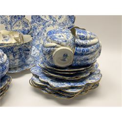 An Edwardian Chapman teaset, of lobed form decorated with blue transfer printed foliate decoration, comprising twelve cups, twelve saucers, nine side plates, and two cake plates. 