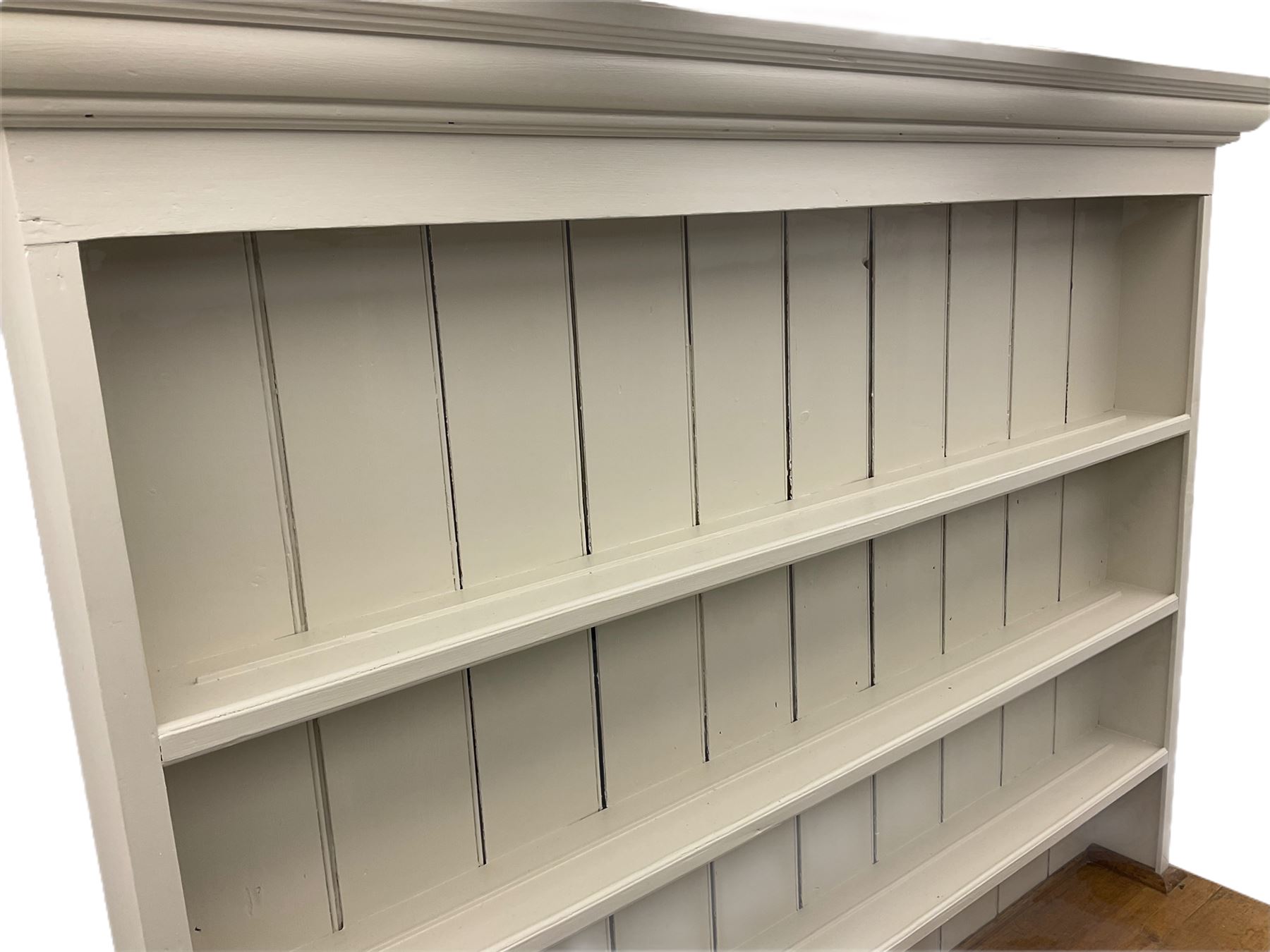 Victorian pine dresser, raised painted three heights plate rack with projecting cornice, waxed top over pained base fitted with three drawers and two double cupboards, bracket feet