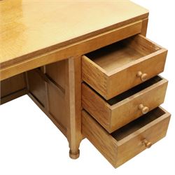 Mouseman - adzed oak kneehole dressing table with mirror, the rectangular adzed top with raised back and canted corners with fixed central pivoting mirror with scallop-carved cresting rail, over an arched recessed kneehole flanked by three graduating drawers to each side with turned knob handles, raised on octagonal feet, with carved mouse signature, by the workshop of Robert Thompson of Kilburn