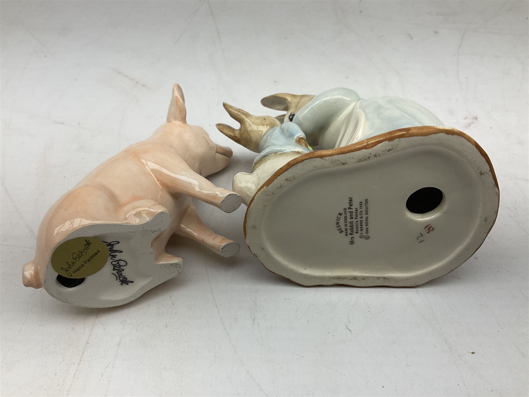 John Beswick figure of a seated piglet, Beswick Beatrix Potter Mrs Rabbit and Peter figure, and quantity of Sandland Character Ware jugs