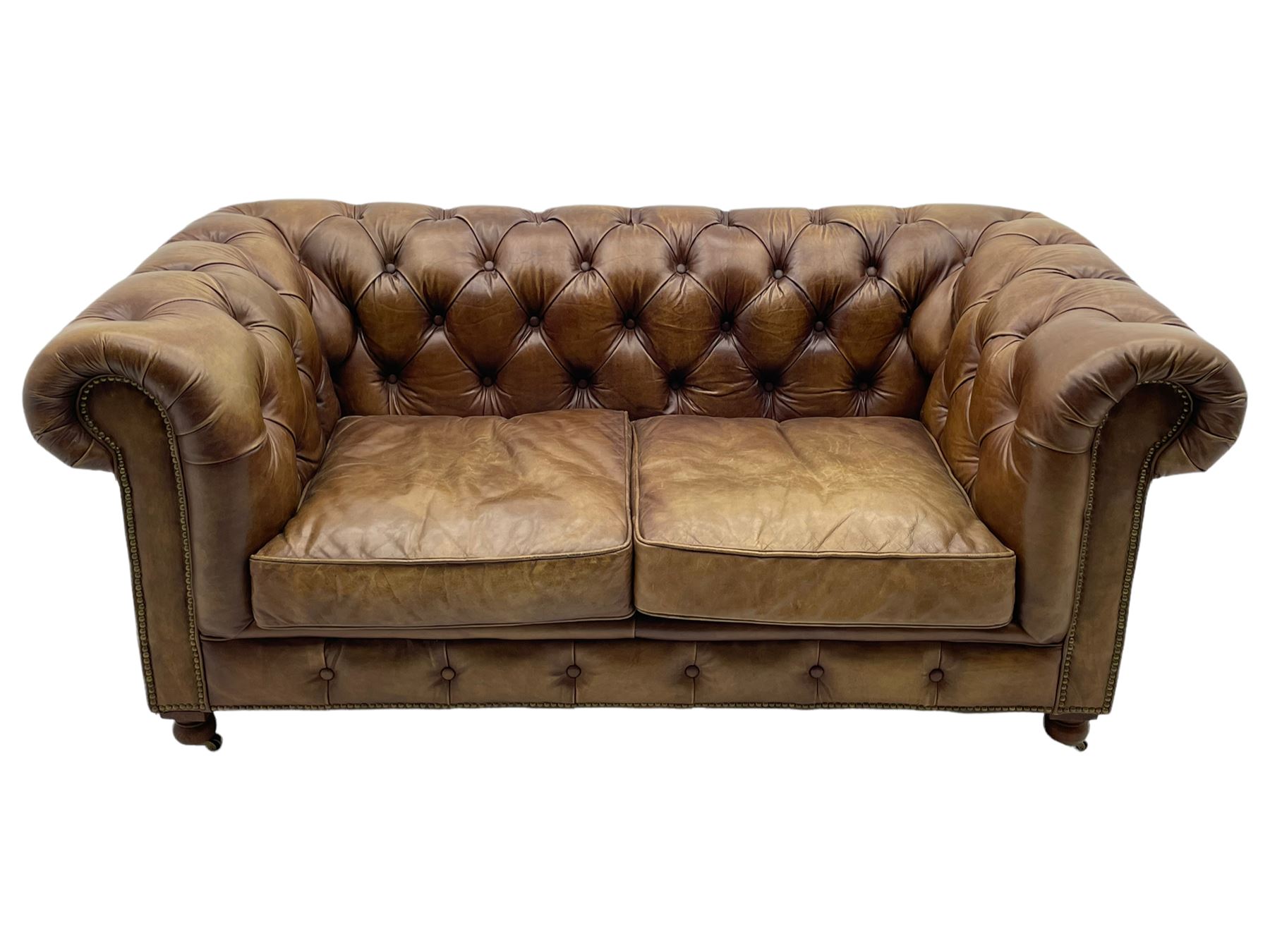 HALO - Chesterfield style two seat sofa upholstered in buttoned brown leather with stud work, on turned feet with castors