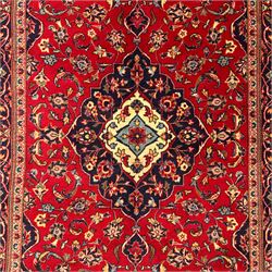 Central Persian Kashan rug, crimson ground with central medallion with  quarter medallions in each corner and decorated with floral sprays and palmettes, dark blue main border with repeating palmette and vine pattern   framed by small guard border with floral meanders 