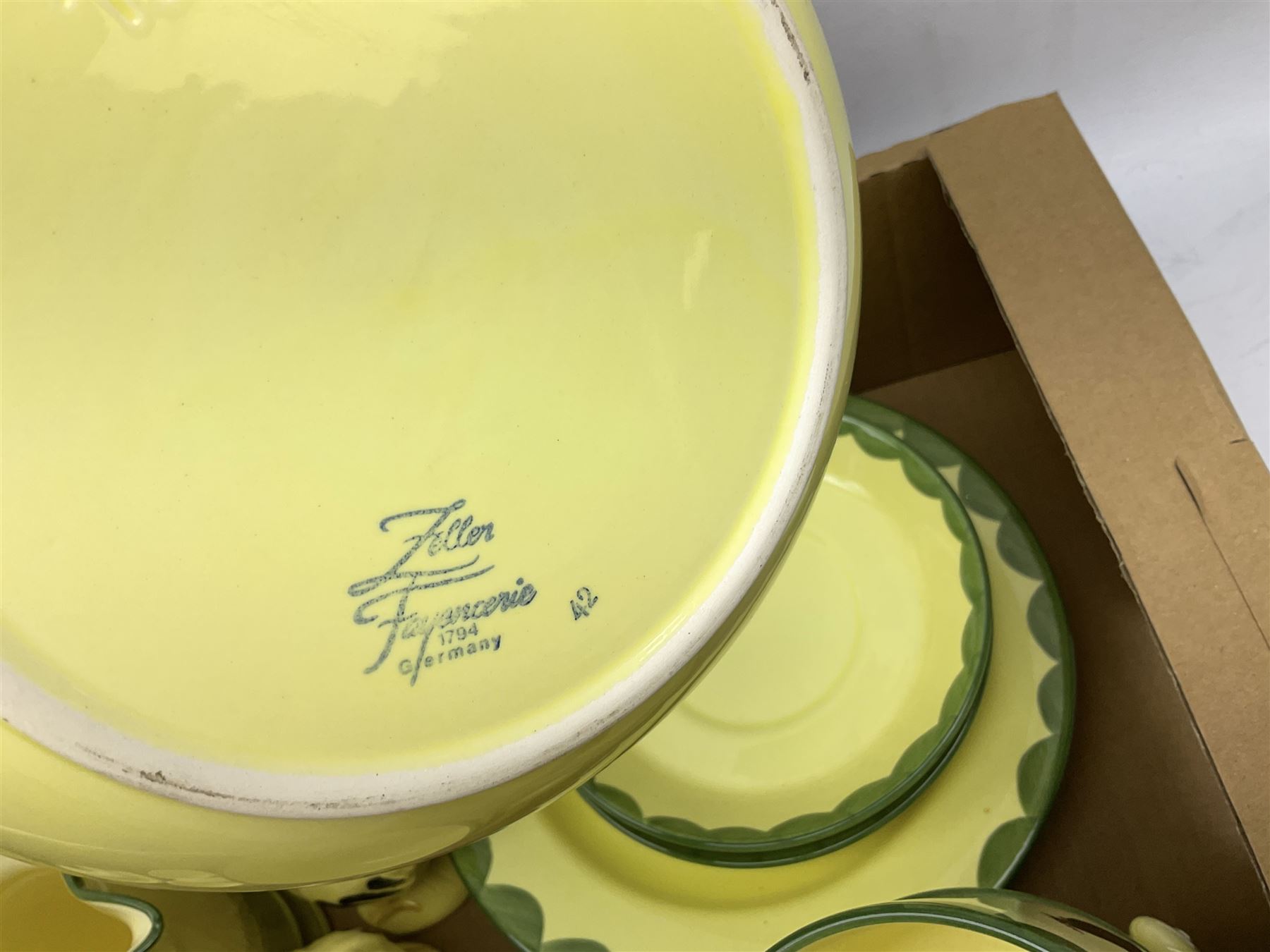 Zeller Fayencerie dinner and tea wares, decorated in cockerels against a yellow ground, with green scalloped border, comprising cake stand, two plates, bowl, three large teacups and saucers, coffee pot, milk jug, cream jug, lidded sugar bowl, pair of cruets modelled as cockerels, butter dish and cover, and utensils pot, and four similar egg cups, in one box 